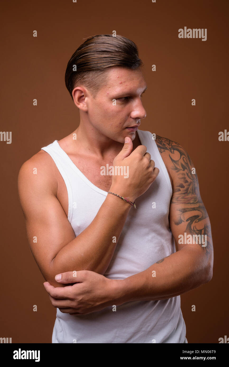 Studio shot der muskulösen Mann gegen braunen Hintergrund Stockfoto