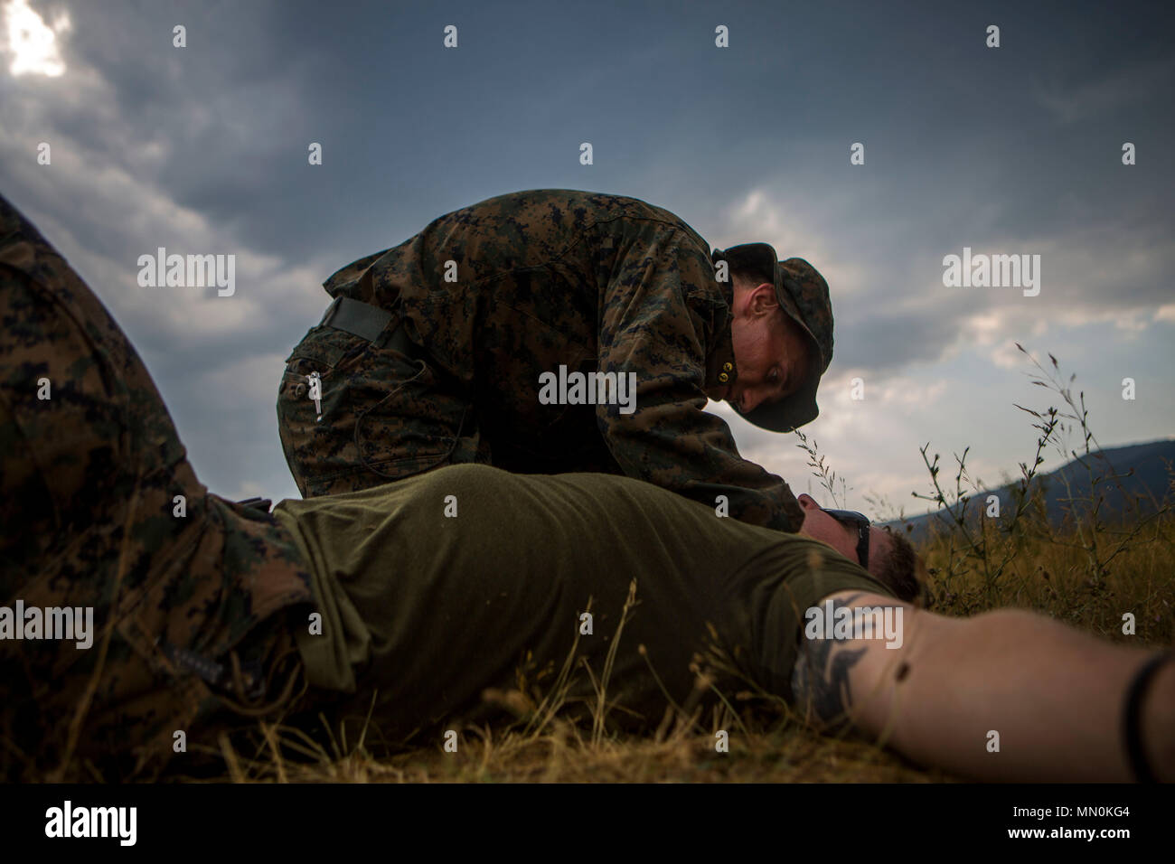 Ein US-Marine mit Schwarzen Meer Drehkraft 17.1 Kontrollen einen simulierten Unfall für weitere Verletzungen als Teil einer Bekämpfung der Lebensretter Station der Scout Sniper Screener bekämpfen Dauertest an Bord Novo Selo, Bulgarien, Aug 5, 2017. Die Kandidaten gehen durch verschiedene strenge Stationen der Karte lesen, festhalten, Bereich Schätzung, land Navigation und zur Bekämpfung der Lebensretter Kursmaterial überprüfen, um zu zeigen, dass Sie geistig und körperlich durchführen können. (U.S. Marine Corps Foto von Pfc. Sarah N. Petrock) Stockfoto