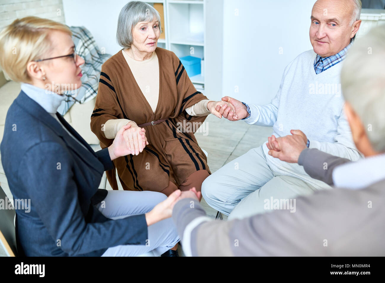 Altere Patienten Im Kreis Sitzend Mit Therapeuten Und Hande Auf