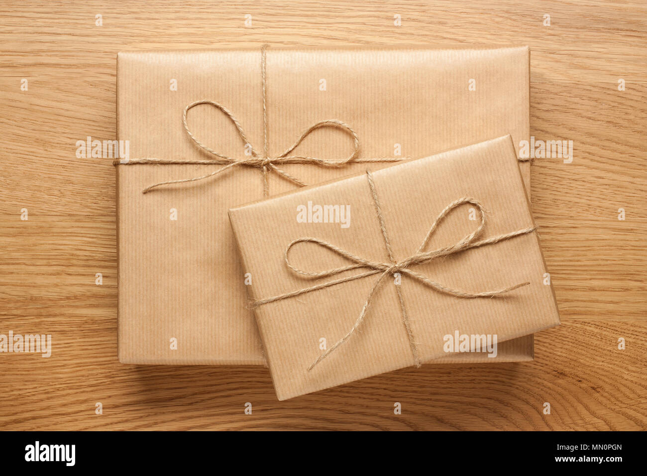 Zwei Geschenkboxen in Kraftpapier auf hölzernen Tisch gewickelt Stockfoto