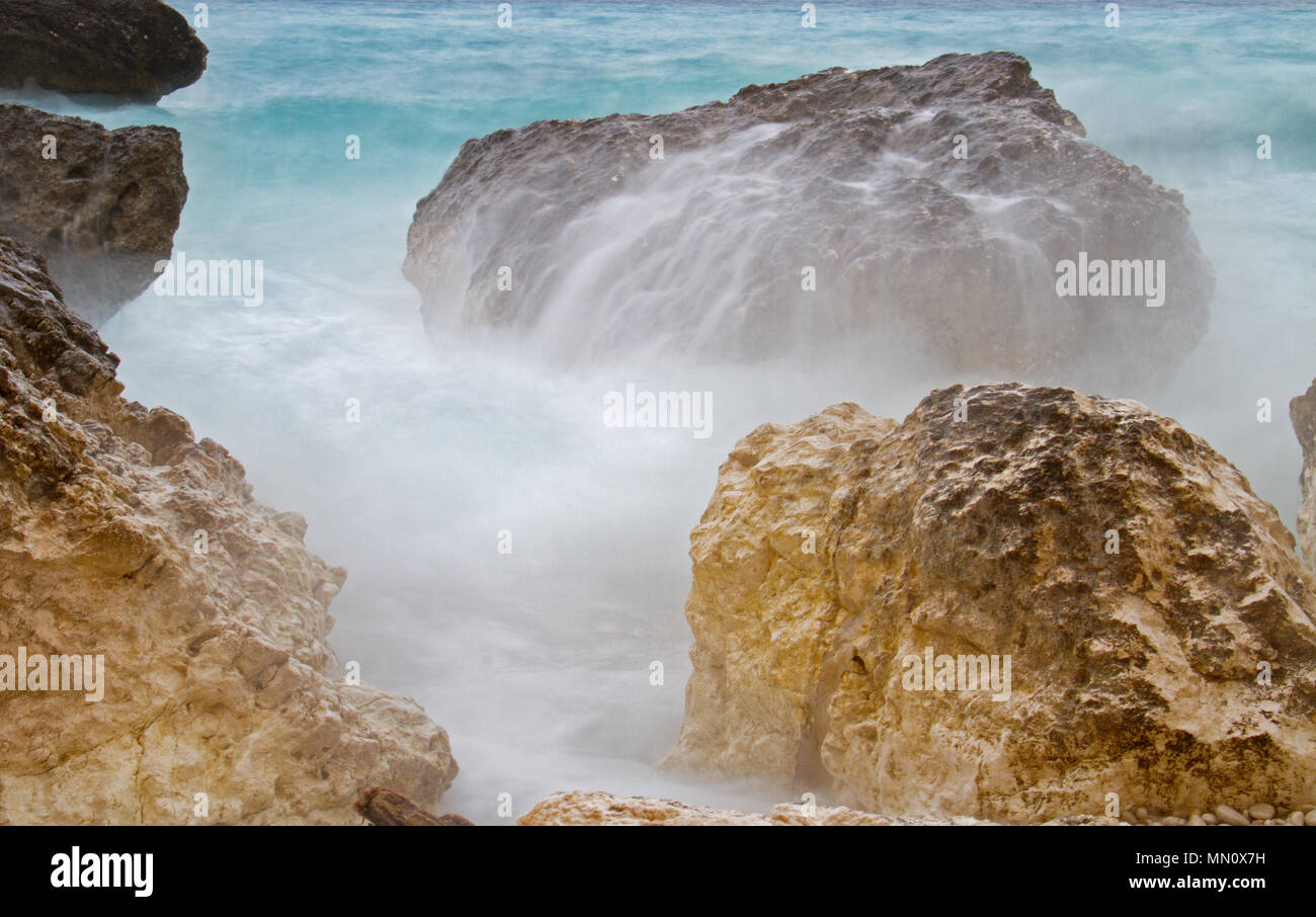 Bewegung verwischt Welle schlagen Kalkstein Felsen am Ufer Stockfoto