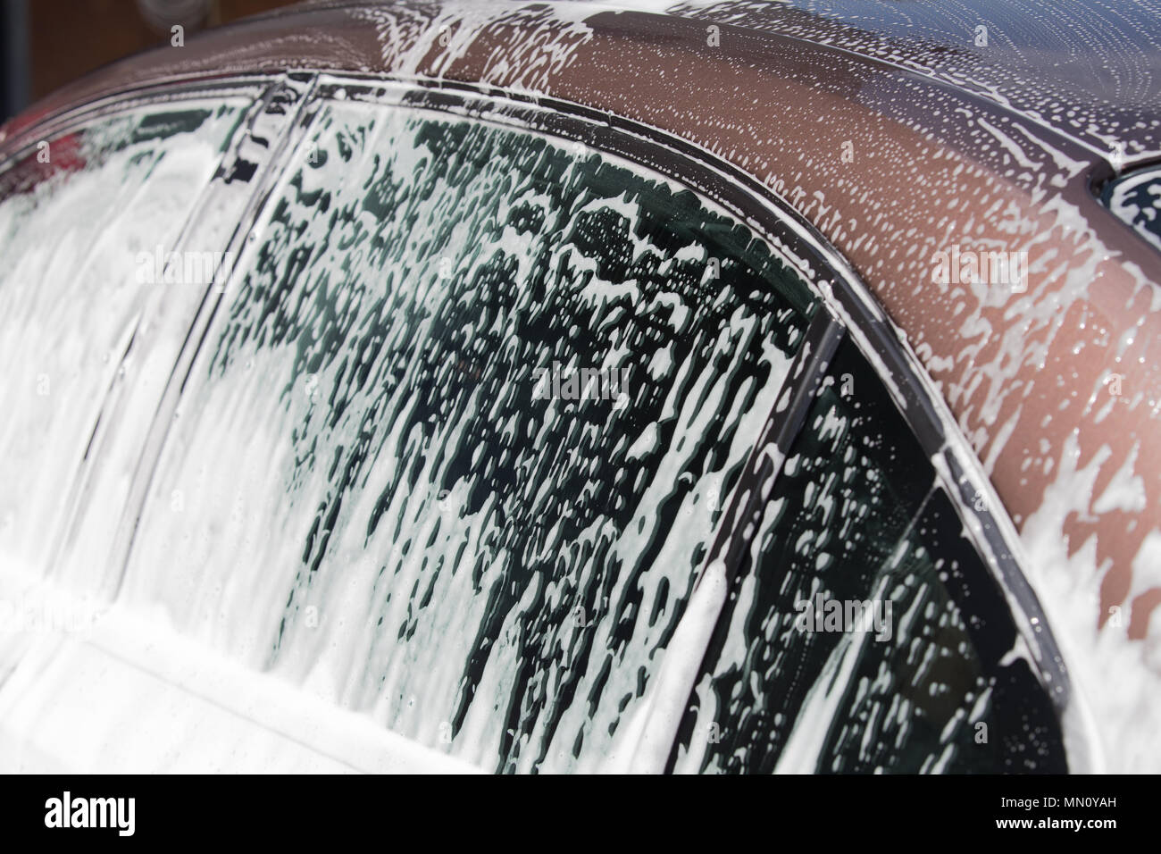 Auto waschen Service. Weißer Schaum fließt auf Autoscheiben. Stockfoto