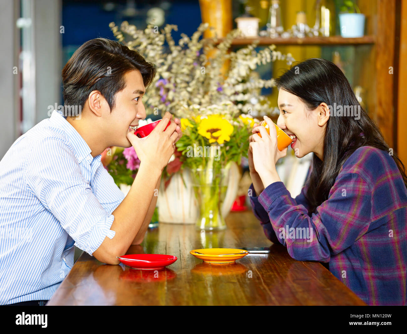 Junge liebende asiatischen Paar von Angesicht zu Angesicht Spaß Kaffee zu trinken. Stockfoto