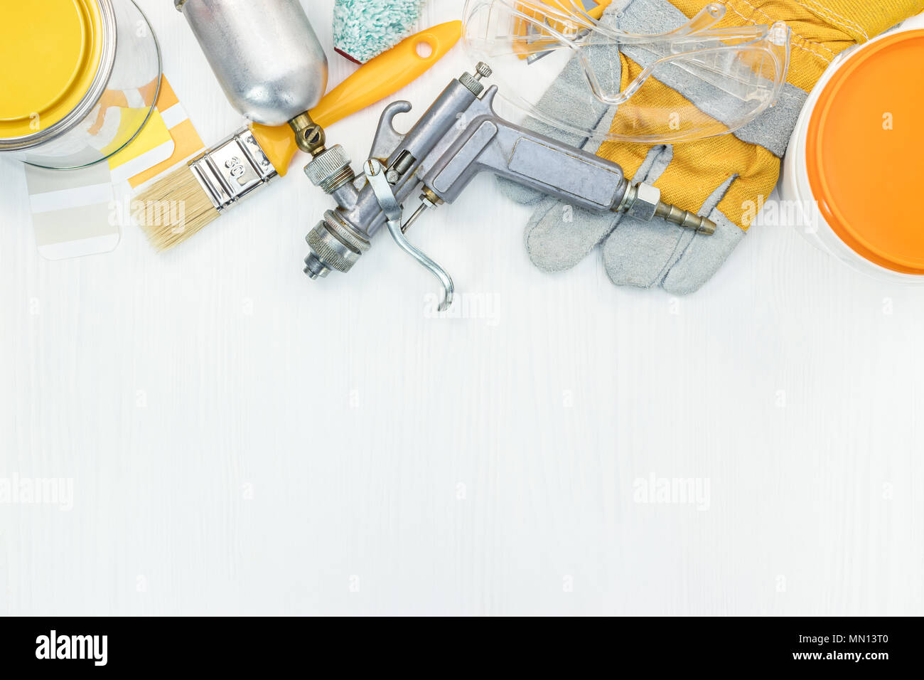 Werkzeuge für Haus Renovierung. Pinsel, Roller, Handschuhe, Lackdosen und Spritze auf einer weißen Holz- Hintergrund Stockfoto