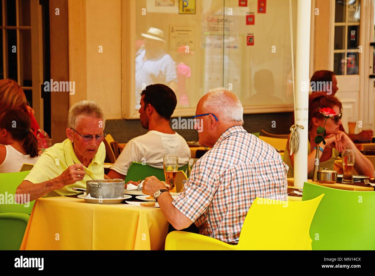 Touristen Mittagessen in einem Restaurant Bürgersteig entlang der R 25 de Abril Straße in der Altstadt, Lagos, Algarve, Portugal, Europa. Stockfoto