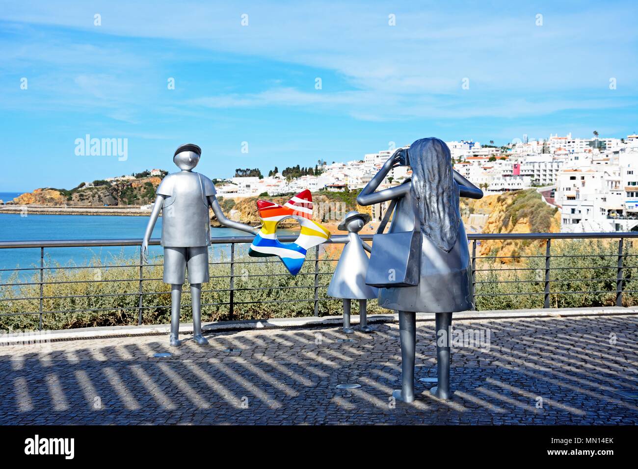 Metall Skulptur einer Frau ein Foto von ihrem Mann und ihrer Tochter am Miradouro do Pau da Bandeira mit Blick auf die Stadt und das Meer an der Rückseite Stockfoto
