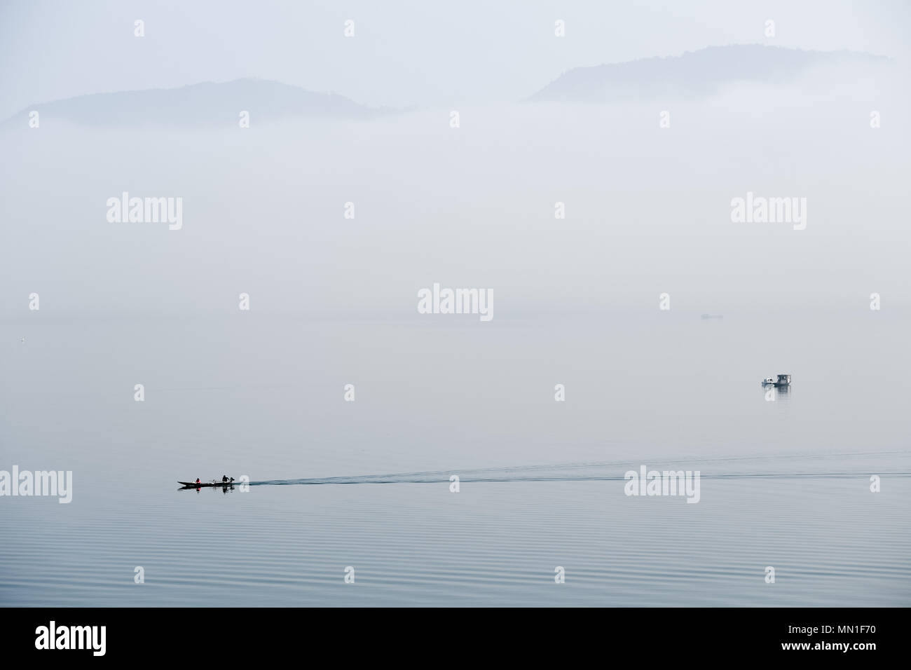 Huangshan, Anhui Chinas Provinz. 14 Mai, 2018. Angeln Boote segeln auf der Taiping See durch Nebel in Beijing ummantelt, der ostchinesischen Provinz Anhui, 14. Mai 2018. Credit: Zhang Duan/Xinhua/Alamy leben Nachrichten Stockfoto