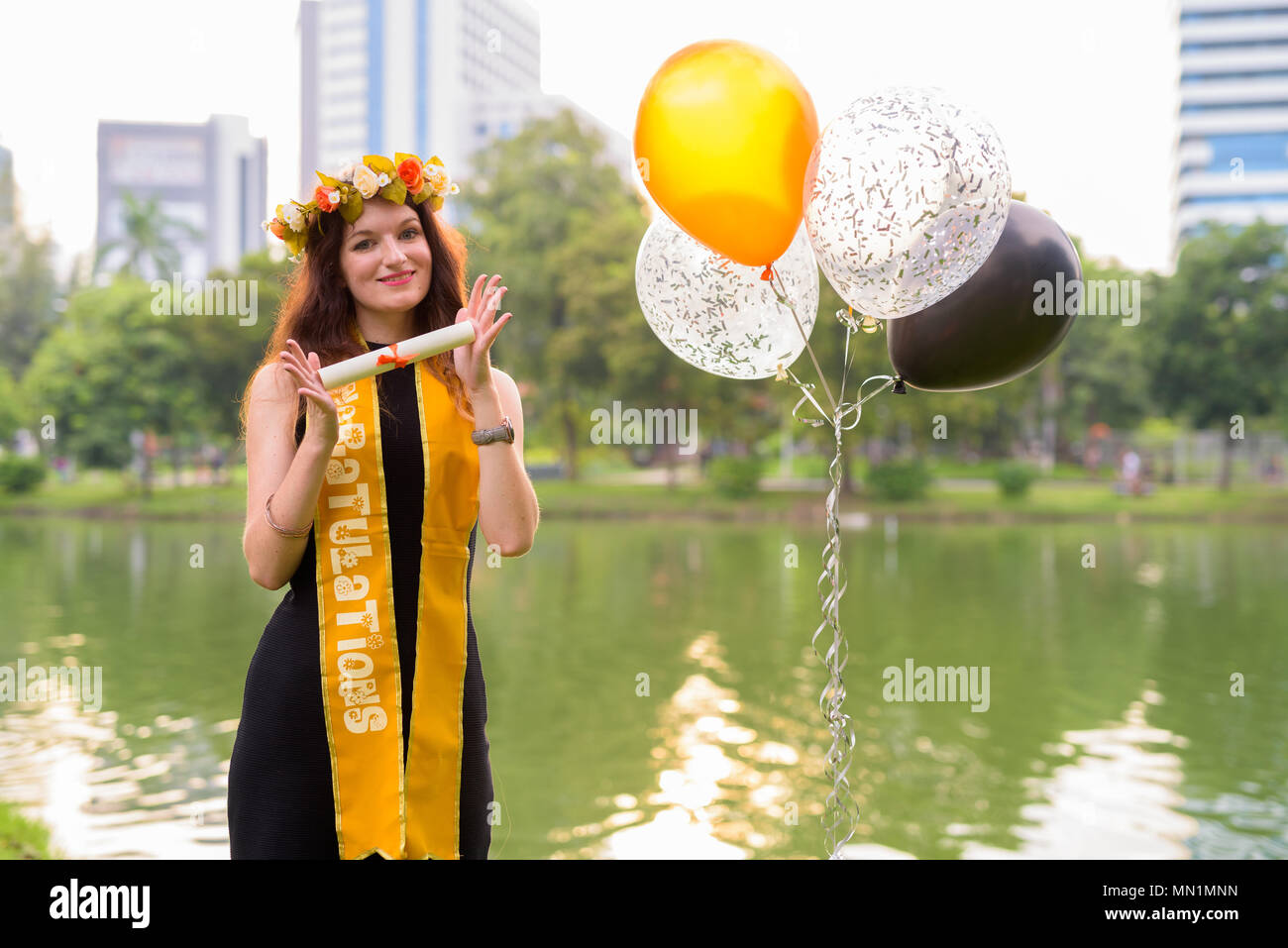 Junge schöne Frau Abschluss feiern im Park in Bang Stockfoto