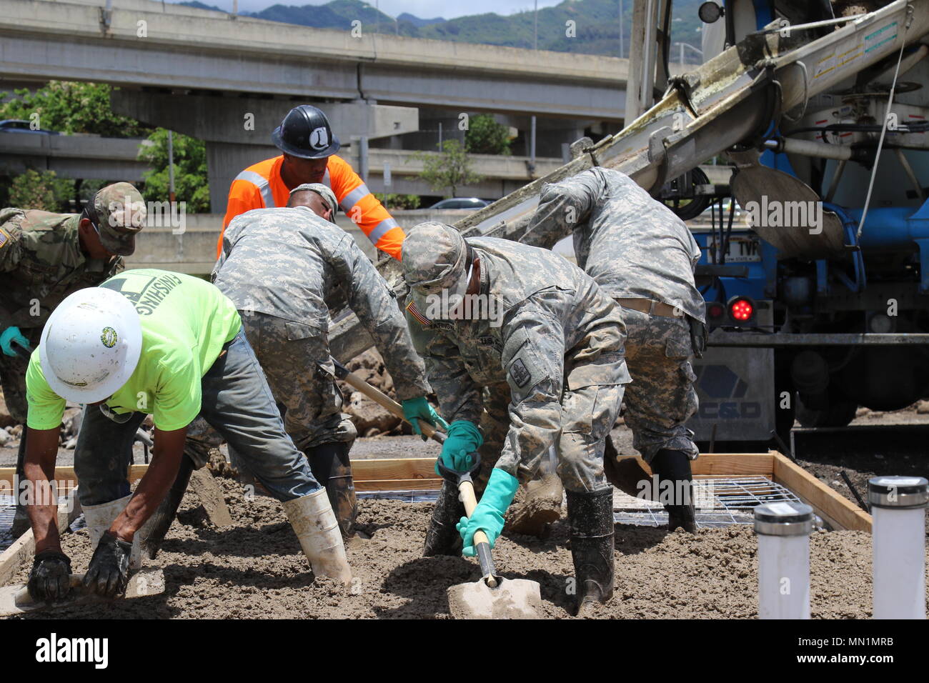 Die Soldaten der Alpha Co 227 Brigade Ingenieur Bataillon den Grundstein legen für Wohnungen am künftigen Standort des Kahauiki Dorf in Honolulu, Hawaii August 9, 2017. Kahauiki Village ist eine Gemeinschaft, die preisgünstige 1- und 2-Schlafzimmer Wohnungen für Obdachlose Familien auf Oahu als Teil der obdachlosen relocation Projekt anbieten. Wenn abgeschlossen, Kahauiki Dorf wird voraussichtlich über 600 Erwachsene und Kinder zu Haus. (U.S. Army National Guard Foto von Sgt. Teisha A. Mellein-Fortson) Stockfoto