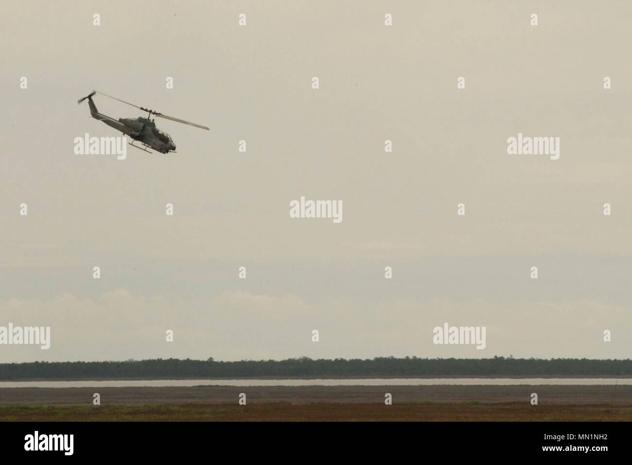 Eine AH-1Z Viper Kampfhubschrauber simuliert einen Angriff auf einen fiktiven Ziel beim Close Air Support Training bei BT11, Atlantic Flugplatz, N.C., Aug 3, 2017. Close Air Support ist Luft durch Flugzeuge gegen feindliche Ziele, die in der Nähe von Friendly Kräfte sind. (U.S. Marine Corps Foto von Lance Cpl. Abrey D. Liggins) Stockfoto