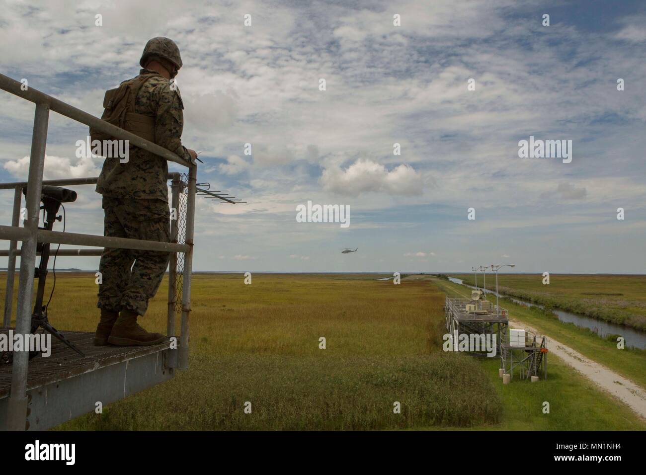 Ein Marine mit 2. Air Naval Geschützfeuer Liaison Unternehmen beobachtet ein Flugzeug während Close Air Support Training bei BT11, Atlantic Flugplatz, N.C., Aug 3, 2017. Close Air Support ist Luft durch Flugzeuge gegen feindliche Ziele, die in der Nähe von Friendly Kräfte sind. (U.S. Marine Corps Foto von Lance Cpl. Abrey D. Liggins) Stockfoto