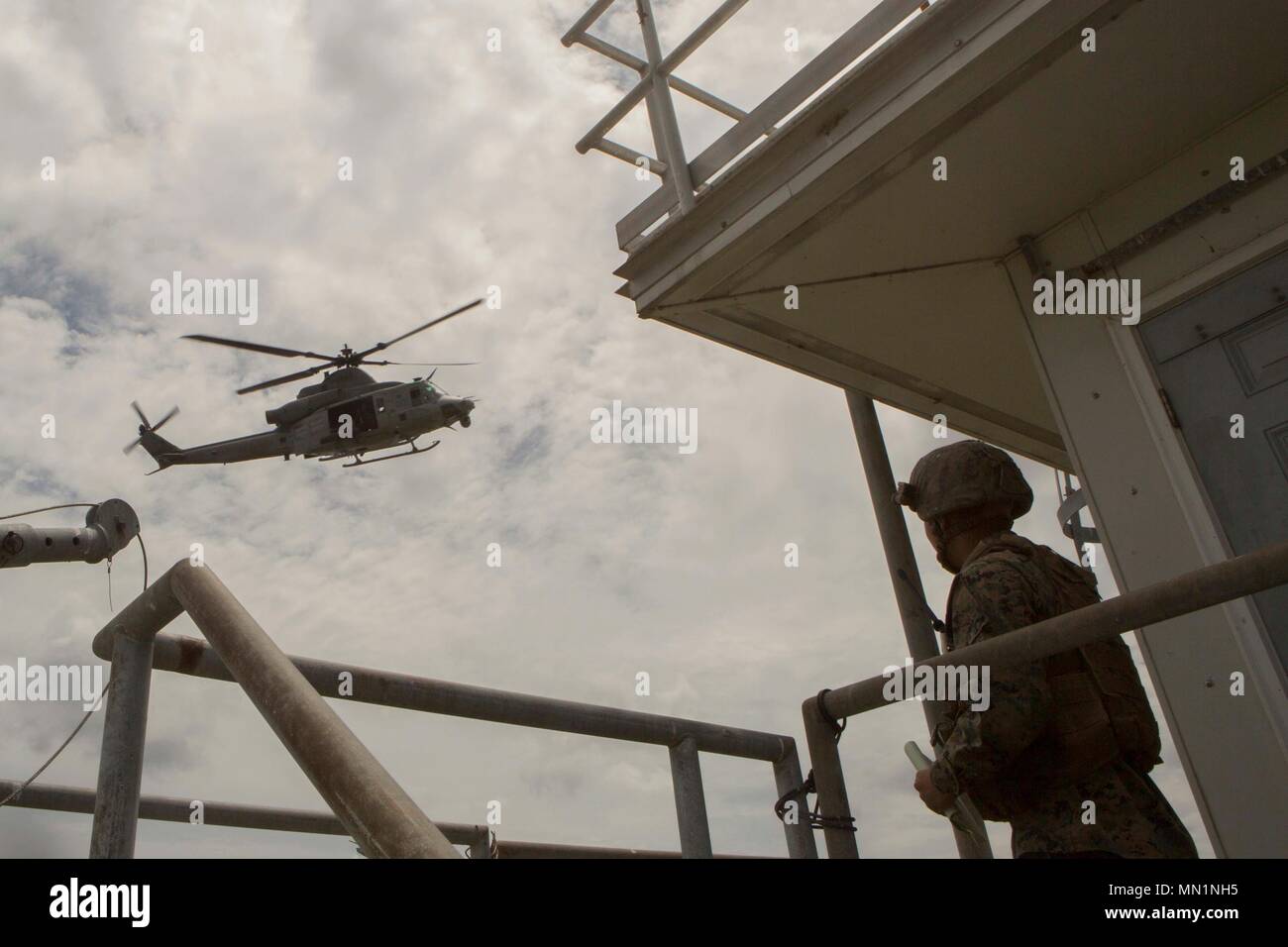 Ein Marine mit 2. Air Naval Geschützfeuer Liaison Unternehmen beobachtet eine UH-1Y Huey Utility Helicopter Flying Overhead während Close Air Support Training bei BT11, Atlantic Flugplatz, N.C., Aug 3, 2017. Close Air Support ist Luft durch Flugzeuge gegen feindliche Ziele, die in der Nähe von Friendly Kräfte sind. (U.S. Marine Corps Foto von Lance Cpl. Abrey D. Liggins) Stockfoto