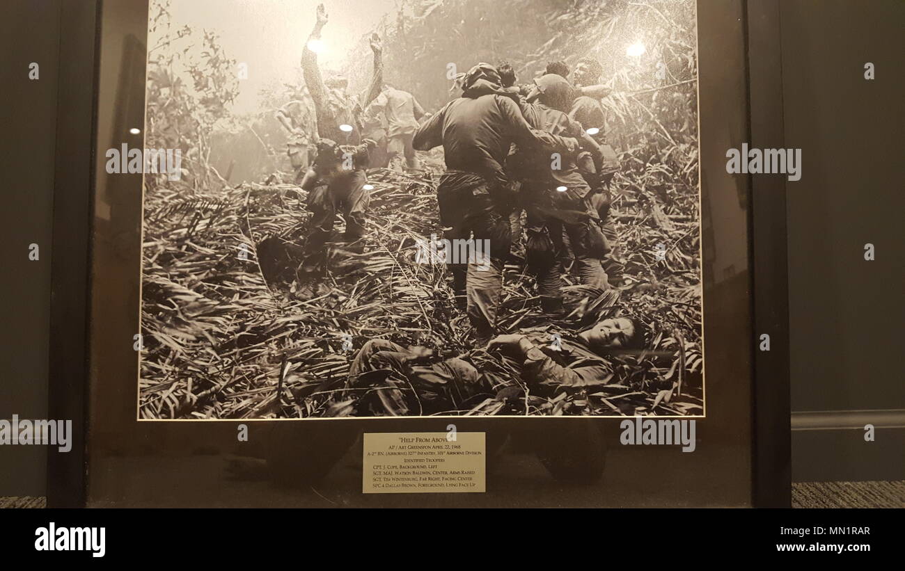 Eine Kopie der "Hilfe von Oben", die in der Zentrale der 2.BATAILLON hängt, 327 Infanterie Regiment, 101St Airborne Division (Air Assault). Das Foto wurde von Kunst Greenspon, um die 101 gespendet, wenn er als Ehrenmitglied der 327 Infanterie Regiment im Jahr 2014 eingesetzt wurde. Greenspon identifiziert die Namen und Positionen der Soldaten im Foto. Sgt. Maj Watson Baldwin steht mit seinen Händen die Signalisierung an einem Hubschrauber angehoben. Spc. 4 Dallas Braun legt auf dem Boden Grimassen in den Schmerz. Sgt. Tim helmetless Wintenburg, ganz rechts, Blicke zurück in die Kamera. (Original Foto von Kunst Greenspon Stockfoto