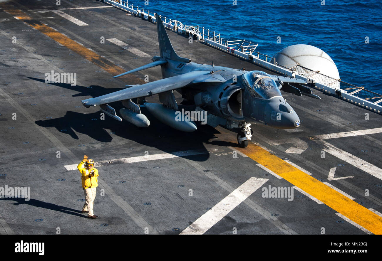 170817-N-WF 272-014 CORAL SEA (Aug. 17, 2017) Chef der Luftfahrt Bootsmann Mate (Handling) Kenji Kimura, aus Nussbaum, Calif., Signale an ein AV-8B Harrier, zugeordnet zu den 'Kater' der Marine Attack Squadron (VMA) 311, von der Flight Deck des Amphibious Assault ship USS BONHOMME RICHARD (LHD6). VMA-311 ist Abschluss seiner "abschiedstour" mit Bonhomme Richard Expeditionary Strike Group (ESG) und die 31 Marine Expeditionary Unit als ESG-Übergänge in die F-35B Blitz II Joint Strike Fighter im Winter 2017. Die BHR ESG führt derzeit Zertifizierung (CER Stockfoto