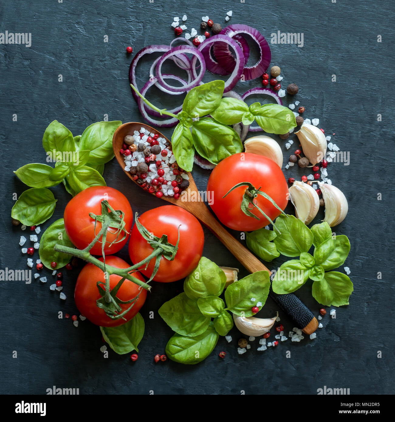 Tomaten Basilikum Knoblauch und Gewürze auf einem Tisch aus Stein in der Form von Herzen gesund essen Konzept Stockfoto