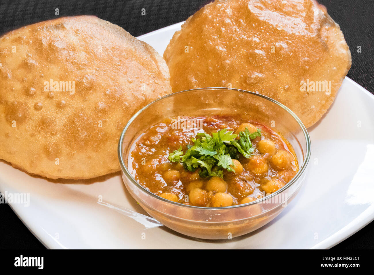 Köstliche Chole Bhature (würzige weiße Kichererbsen) indischen Punjabi Küche in Glasschale auf weißem Hintergrund in Indien serviert. Stockfoto