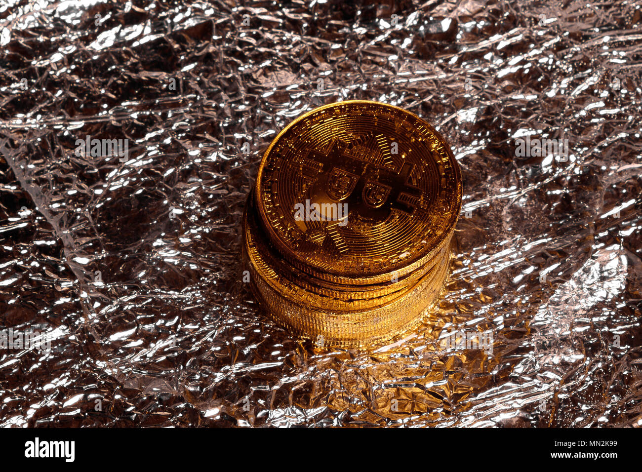 Stapel von Golden physischen Bitcoins auf einer Folie Hintergrund Stockfoto