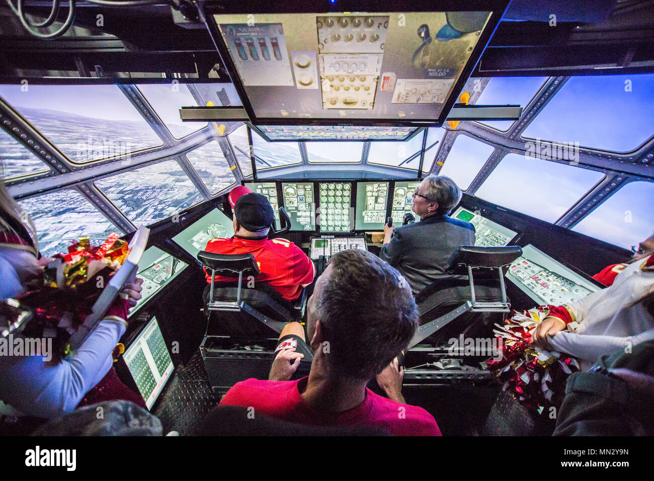 Vertreter der Kansas City Chiefs NFL Team und McDonald's Restaurant betreiben eine C-130 Flugzeuge Simulator während einer Tour von Rosecrans Air National Guard Base, St. Joseph, Mo, 12.08.15, 2017. Der Besuch war Teil von einem McDonald's Restaurant Herz Amerikas Co-Op 15-Tour für lokale Wohltätigkeitsorganisationen. Pensionierter Leiter Spieler Tony Adams und Gary Spani waren anwesend, sowie aktuelle Cheerleadern des Teams. (U.S. Air National Guard Foto: Staff Sgt. Patrick Evenson) Stockfoto