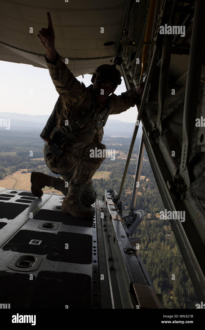 KC-130J Hercules ist ein mehrseitiges Militärflugzeug, das Luftbetankung, Frachttransport und Lufteinsätze für gemeinsame US-Streitkräfte unterstützt. Das Archivbild dokumentiert einen Soldaten der Special Forces, der den geschätzten Ankunftszeitpunkt an eine Drop-Zone während des statischen Line-Jumpmaster-Kurses in der Joint Base Lewis-McChord im Jahr 2017 signalisiert. Stockfoto