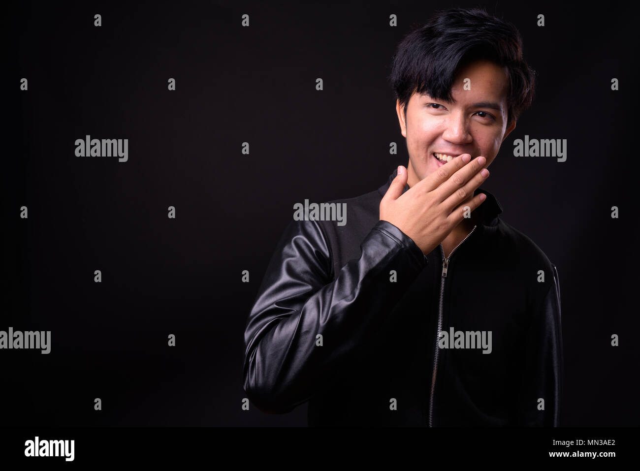 Die Jungen gut aussehenden asiatischer Mann auf schwarzem Hintergrund Stockfoto