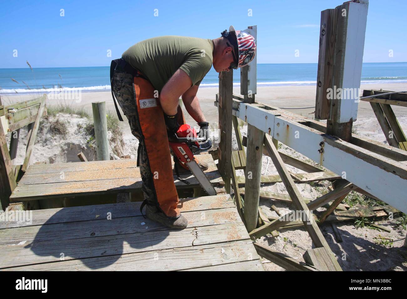 Ein Marine mit 8. Techniker Bataillon verwendet eine Kettensäge hinunter zu einem freien Strand Haus in Onslow Strand, Camp Lejeune, N.C., Aug 30. Der Strand Häuser wurden mit schweren Geräten, Fäustel und per Hand zerrissen. Die cabanas sind zerstört Wege für amphibische Landung Fahrzeuge während der Übung Bold Alligator zu schaffen, soll im Oktober stattfinden. (U.S. Marine Corps Foto von Cpl. Ashley Lawson) Stockfoto