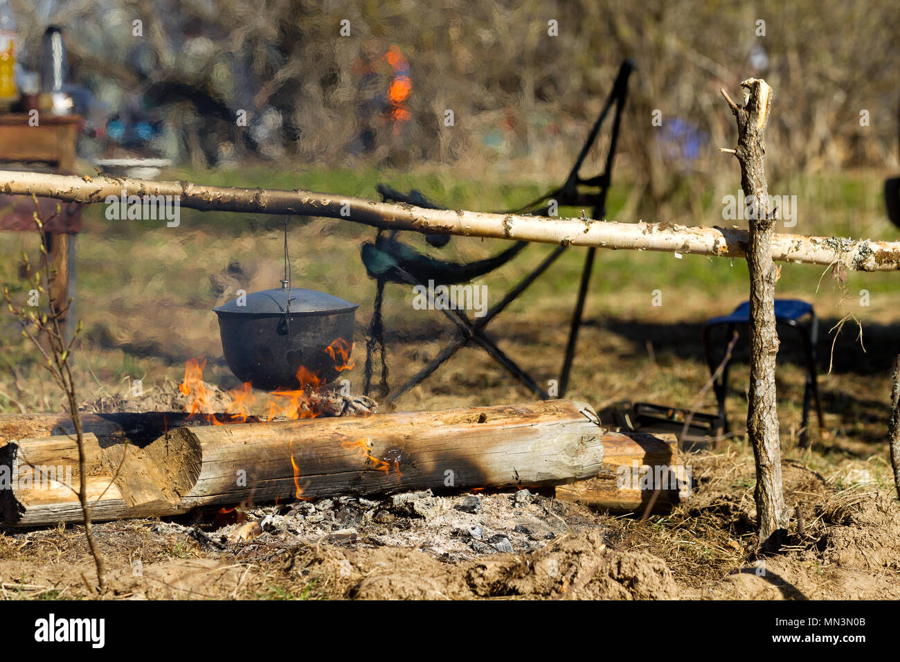 Lagerfeuer. Kochen in ein Lagerfeuer an einem Lagerfeuer, Kochen am Lagerfeuer bei einer Wanderung Stockfoto