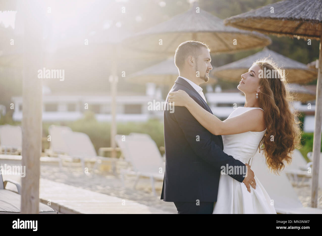 Schönen jungen langhaarigen Braut im weißen Kleid mit ihr junger Ehemann am Strand Stockfoto