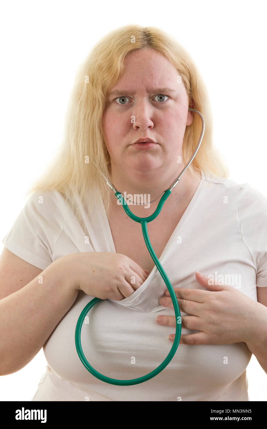 Junge kaukasier blond weiblich Frau suchen, wenn Ihr Herz Kontrolle mit stetoscope auf weißem Hintergrund isoliert überrascht Model Release: Ja. Property Release: Nein. Stockfoto