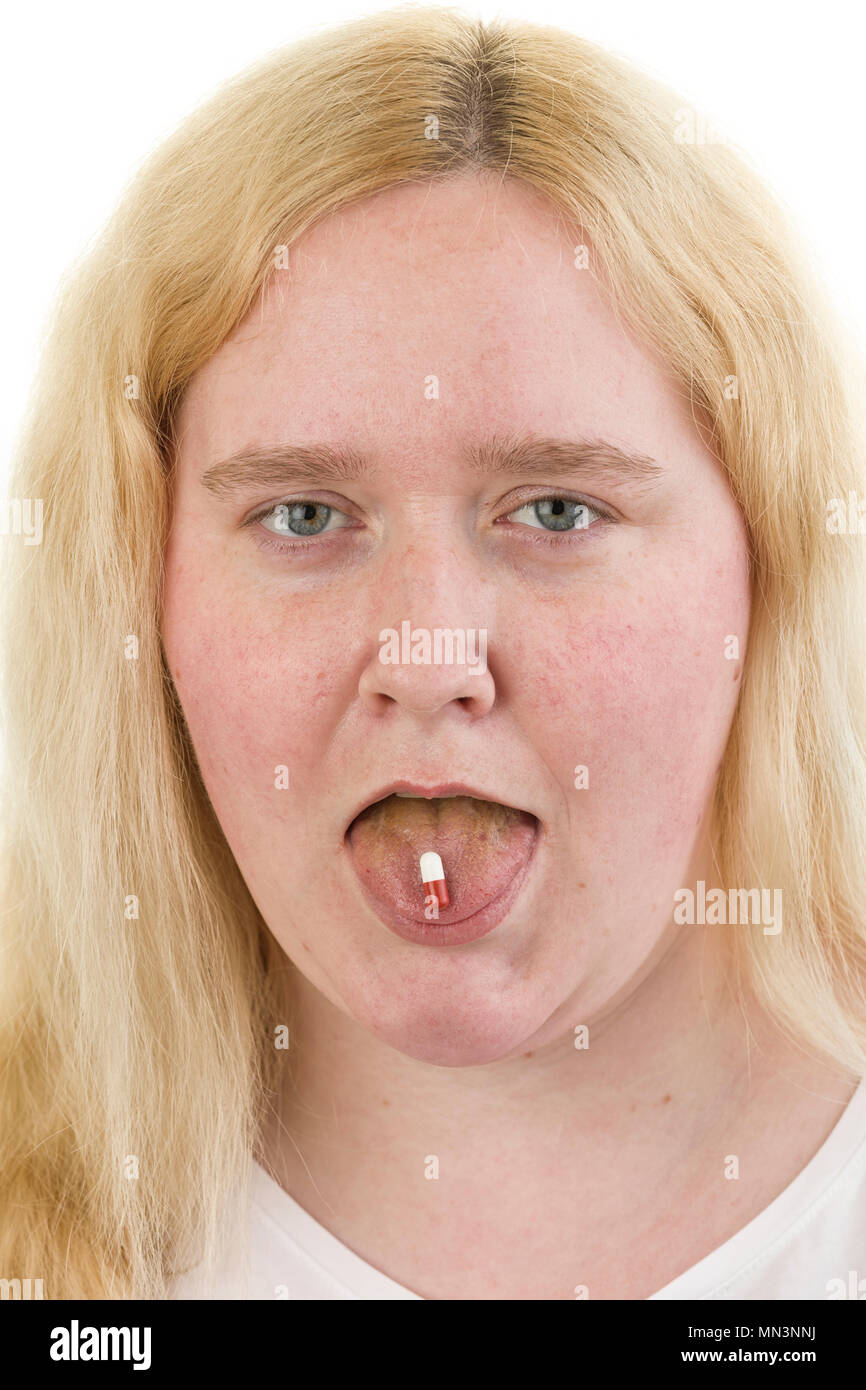 Junge kaukasier blond weiblich Frau heraus haften Zunge mit Medizin Kapsel auf sie isoliert auf weißem Hintergrund Model Release: Ja. Property Release: Nein. Stockfoto