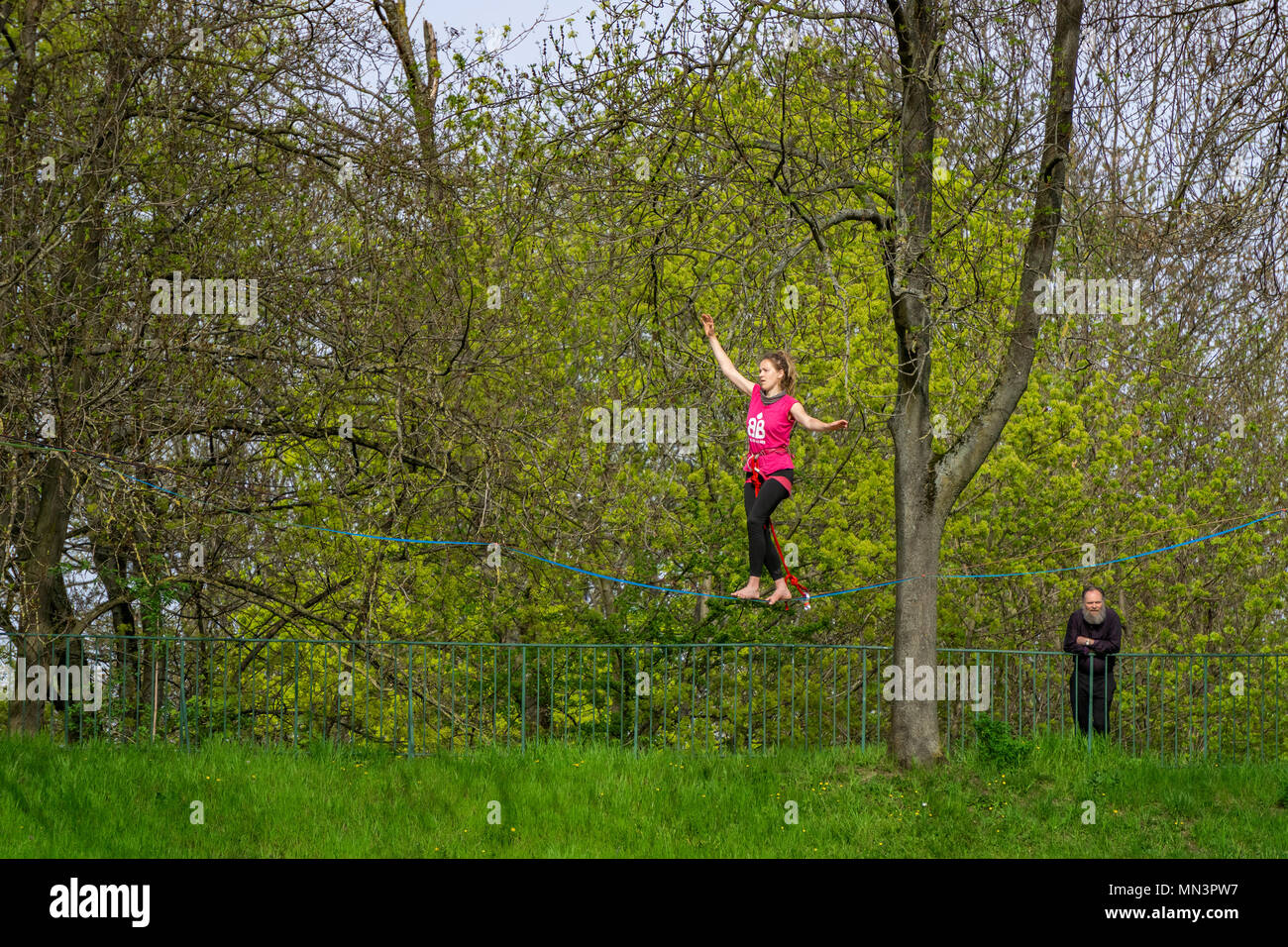 Junge weibliche Seiltänzer zu Fuß auf der Slackline in der Luft in einem Park, Straßburg, Frankreich ausgesetzt. Stockfoto