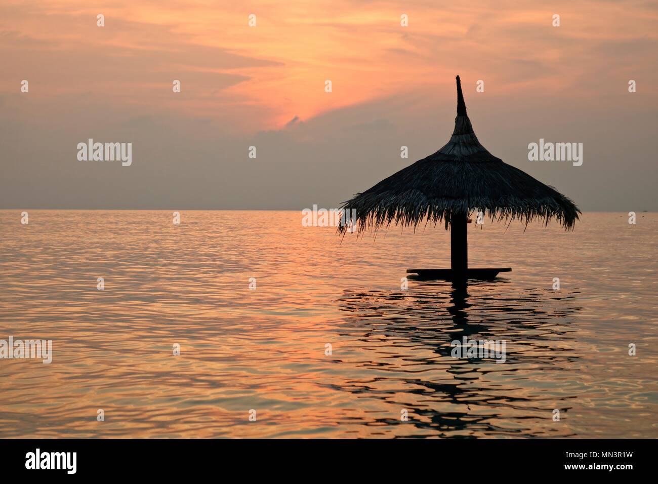 Sonnenschirm im Meer nur nach immensen Sonnenuntergang Stockfoto