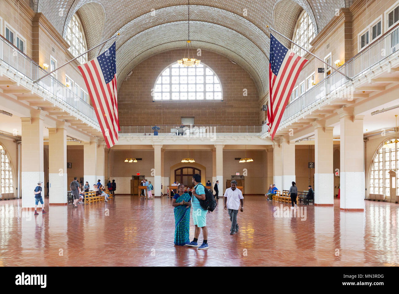 Touristen, die sich in der Großen Halle, Ellis Island Immigration Museum, Ellis Island, New York City, USA Stockfoto
