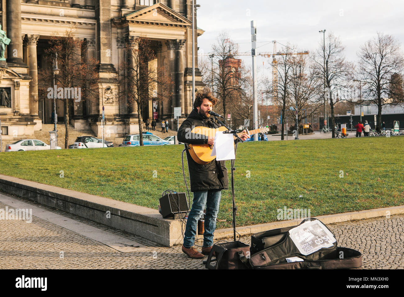 Berlin, Deutschland, 15. Februar 2018: strassenmusiker oder Gitarrist. Man singt und spielt Gitarre auf der Straße im historischen Stadtzentrum oder in der Nähe von Berliner Dom. Stockfoto