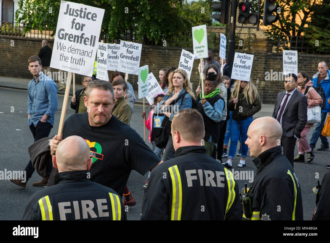 London, Großbritannien. 14 Mai, 2018. Mitglieder der Grenfell Gemeinschaft zeigen ihre Anerkennung für die Londoner Feuerwehr Feuerwehrmänner bilden ein Spalier für die Grenfell Schweigemarsch. Der März, die auf der monatlichen Jahrestag der Feuer braucht, um am 14. Juni 2017, wurde jetzt auf der ursprünglichen Route ab dem Notting Hill methodistische Kirche zurückgekehrt. 71 Menschen in der Grenfell Turm Feuer und über 70 Tote wurden verletzt. Credit: Mark Kerrison/Alamy leben Nachrichten Stockfoto