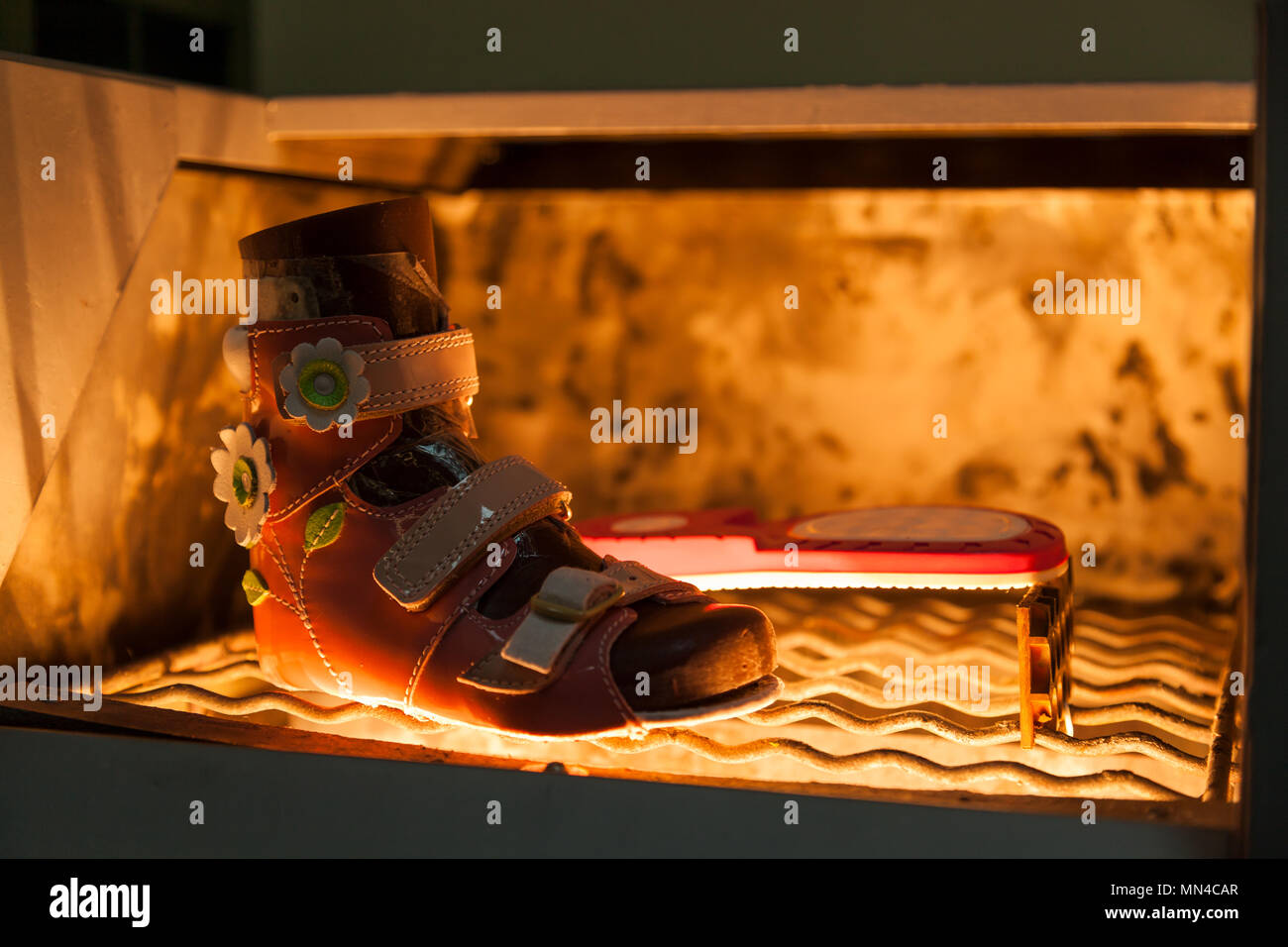 Nahaufnahme der Kinder Sommer Schuhe für Mädchen aus natürlichem Leder trocknet in einem speziellen industriellen Herd. Herstellung von Kinderschuhen Stockfoto