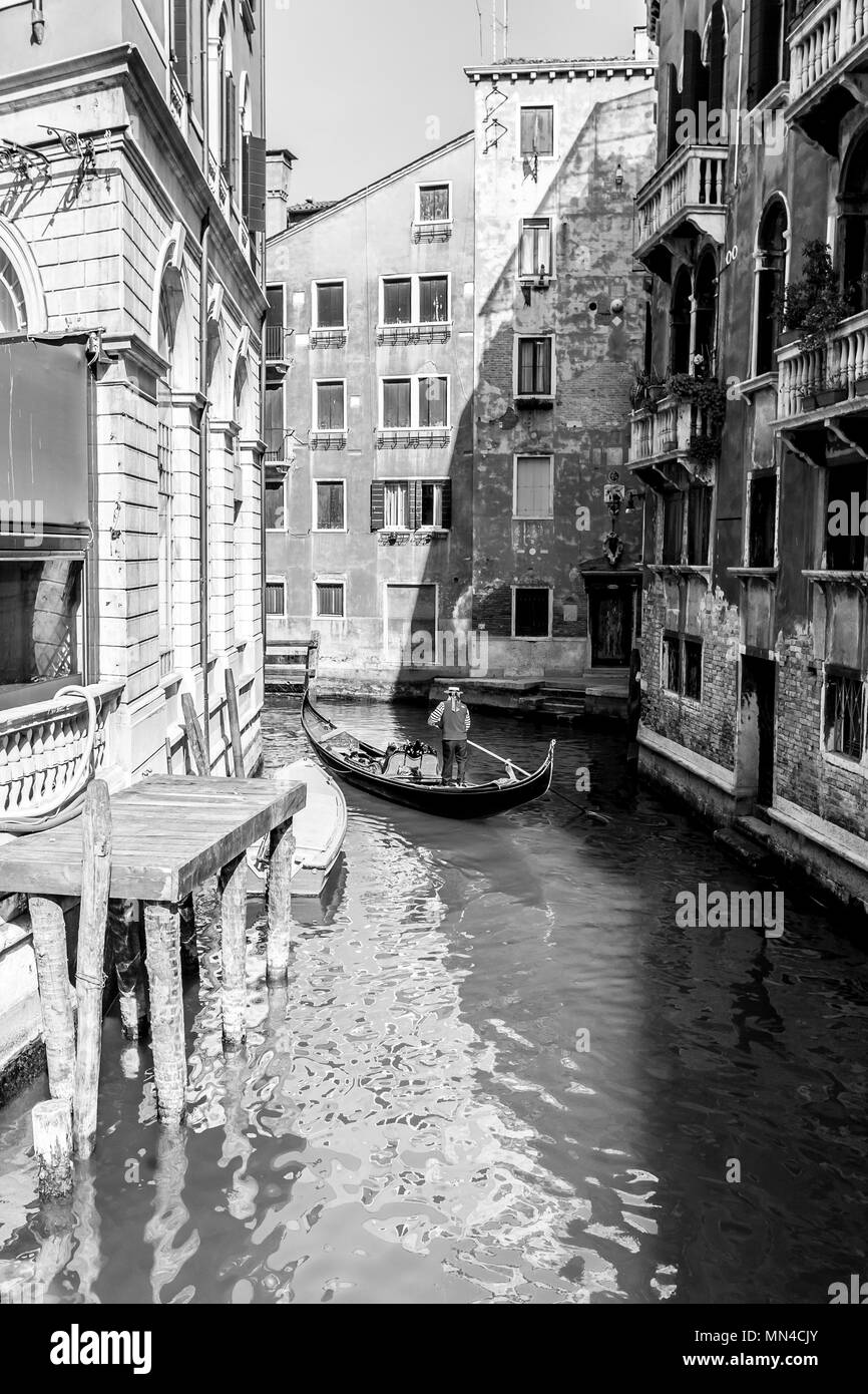 Venedig, Italien. Typische Gondel mit gondoliere Rudern auf einem schmalen Kanal in Venedig, schwarz-weiß-Bild. Stockfoto