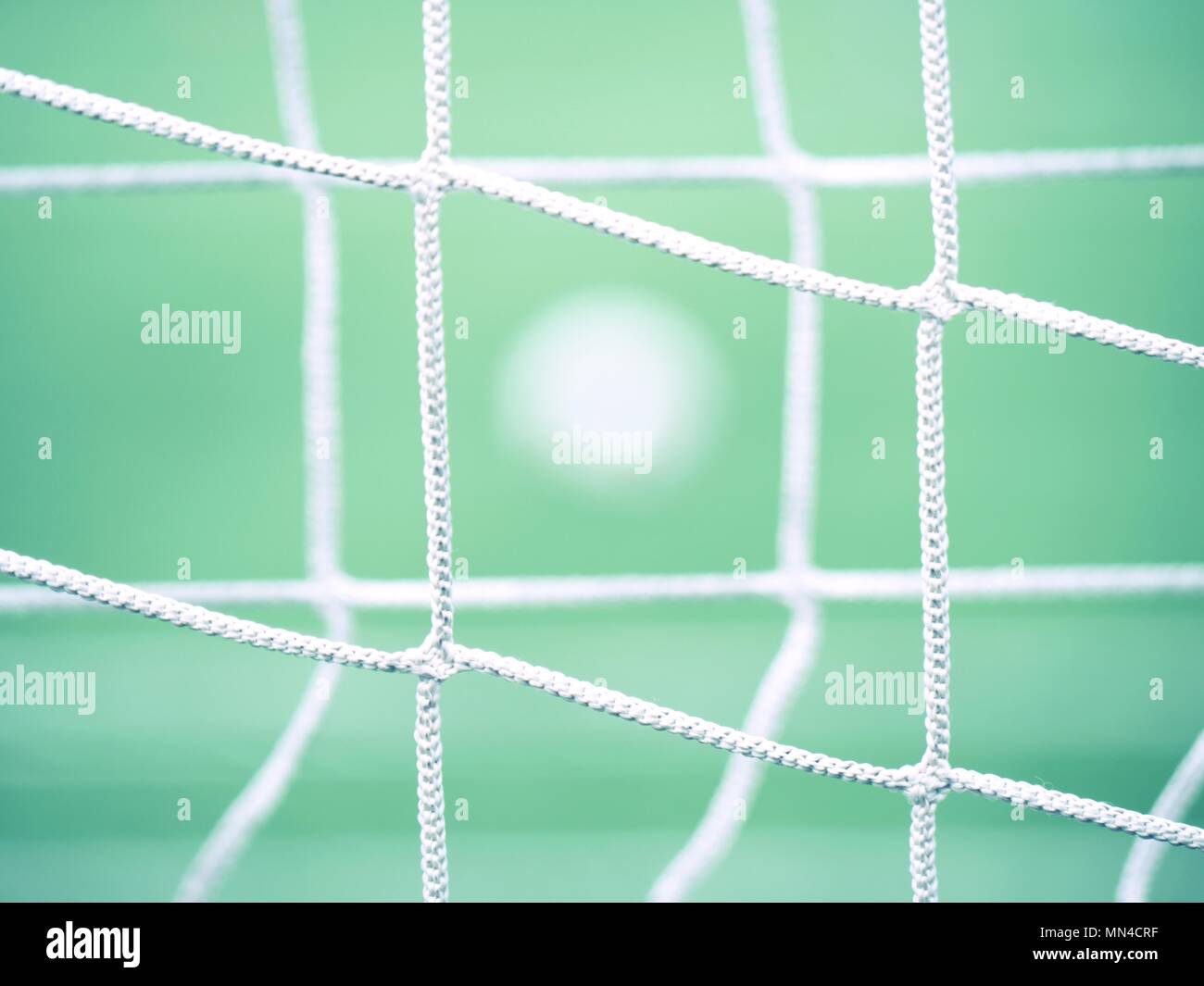 Blick durch Fußball Tor net. Fußball auf grünem Gras durch quadratische net gesehen Stockfoto