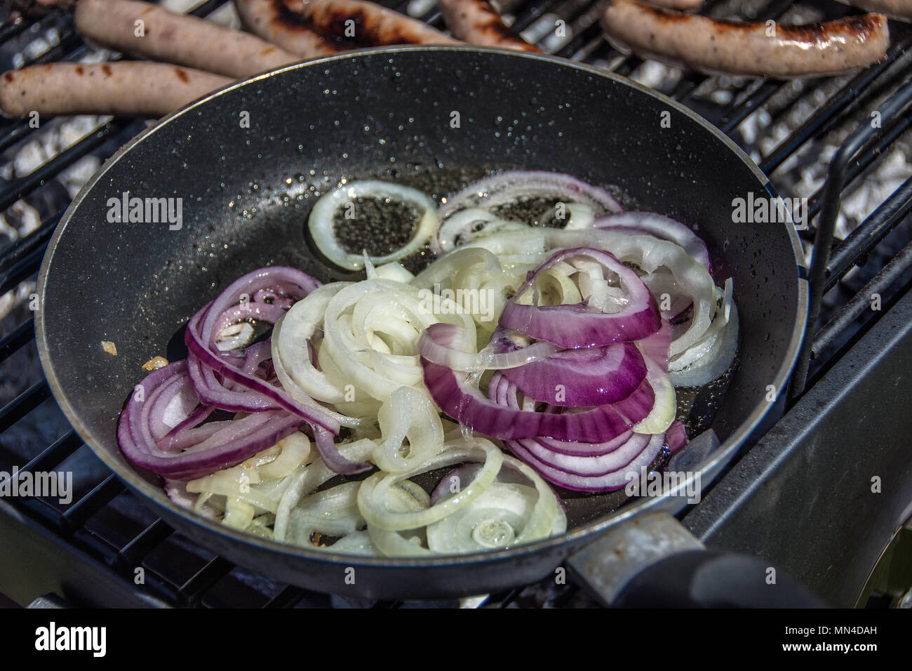 Zwiebeln braten in einer Pfanne auf einem Grill Stockfotografie - Alamy