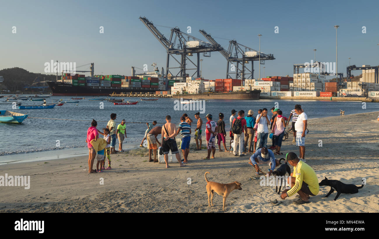 Die Einheimischen am Strand mit einem Containerschiff Ausfahrt aus dem Hafen hinaus, Santa Marta, Magdalena, Kolumbien Stockfoto