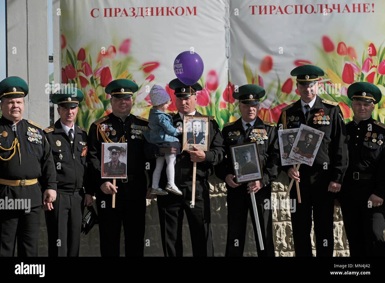 Offiziere der Streitkräfte der Pridnestrovianischen Republik Moldau des halbanerkannten Staates Transnistria halten Bilder von Verwandten, die im Zweiten Weltkrieg gekämpft haben, als die warten, an einer Militärparade anlässlich des Siegestages am 9.. Mai teilzunehmen, die Erinnert an den Sieg der Sowjetunion über Nazi-Deutschland im Zentrum von Tiraspol, dem Hauptstadt- und Verwaltungszentrum der international anerkannten Grenzen Moldawiens, die seit 1992 de facto unter der nicht anerkannten Pridnestrovianischen Republik Moldau, auch Transnistria (PMR) genannt, steht. Stockfoto