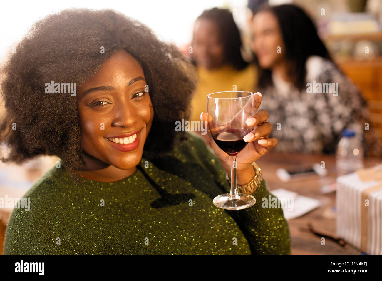 Porträt Lächeln, selbstbewusste junge Frau trinkt Rotwein Stockfoto