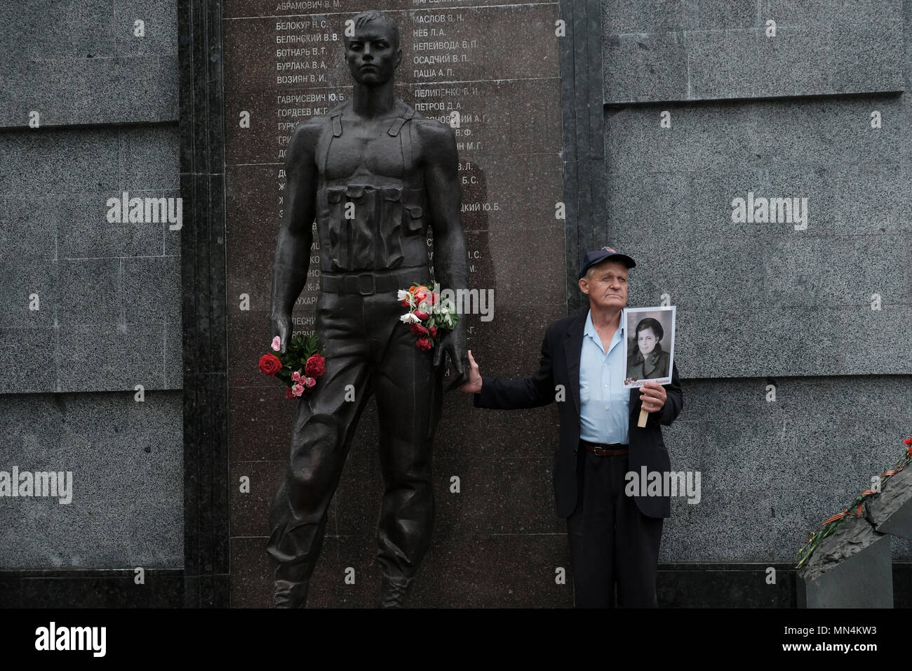 Ein Mann hält ein Foto einer Person, die im Zweiten Weltkrieg Während der Tag des Sieges am 9. Mai, der den Sieg der Sowjetunion über Nazi-deutschland erinnert in der Gedenkstätte der Herrlichkeit, die die Veteranen und die Toten des Zweiten Weltkrieges gedenkt, die Soviet-Afghan Krieg gekämpft, und die 1990-1992 Transnistrien Krieg auf Suvorov Square in Tiraspol die Hauptstadt und das Verwaltungszentrum der international anerkannten Grenzen der Republik Moldau unter der De-facto-Kontrolle der nicht anerkannten Moldawischen Republik Transnistrien Pridnestrovian (PMR) seit 1992. Stockfoto