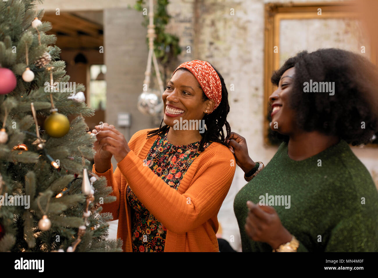 Lächelnde Mutter und Tochter schmücken Weihnachtsbaum Stockfoto