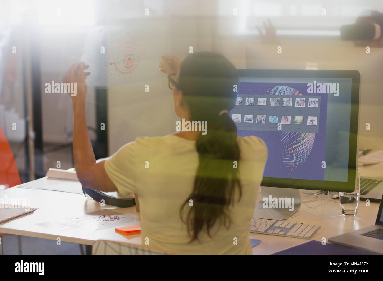 Weibliche Designer anzeigen Transparenz Diagramm am Computer im Büro Stockfoto