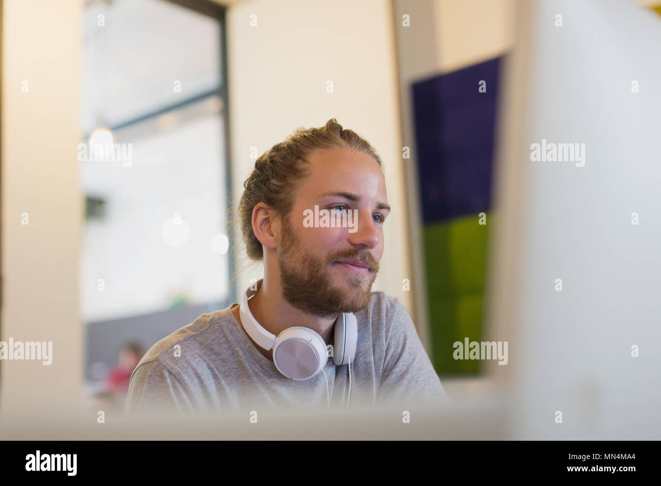 Zuversichtlich, dass kreative Unternehmer mit Kopfhörer am Computer arbeiten Stockfoto