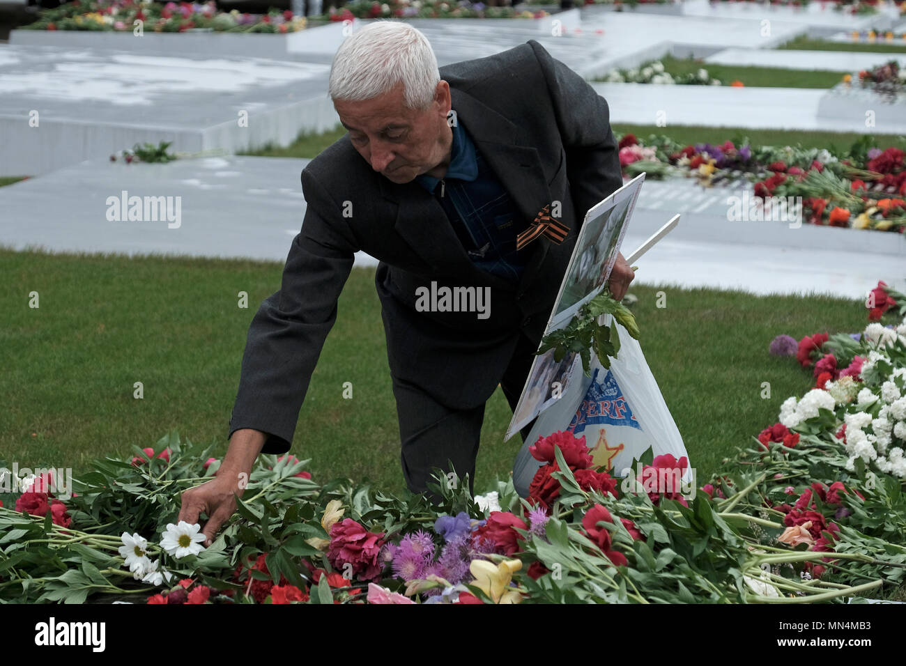 Ein Mann Blumen Verlegung in das Gedächtnis der Herrlichkeit, die die Veteranen und die Toten des Zweiten Weltkrieges gedenkt, die Soviet-Afghan Krieg und die 1990-1992 Transnistrien Krieg auf Suvorov Square in Tiraspol die Hauptstadt und das Verwaltungszentrum der international anerkannten Grenzen der Republik Moldau unter der De-facto-Kontrolle der nicht anerkannten Moldawischen Republik Transnistrien Pridnestrovian (PMR) seit 1992 genannt. Stockfoto