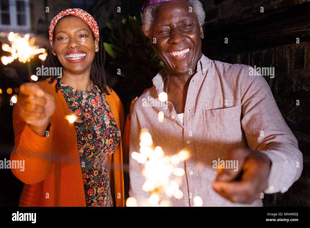Portrait happy senior Vater und Tochter feiern mit Wunderkerzen Stockfoto