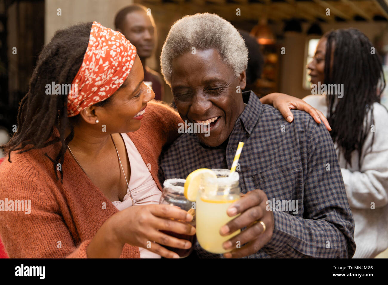 Senior Vater und Tochter toasten Limonade, umarmen auf der Terrasse Stockfoto