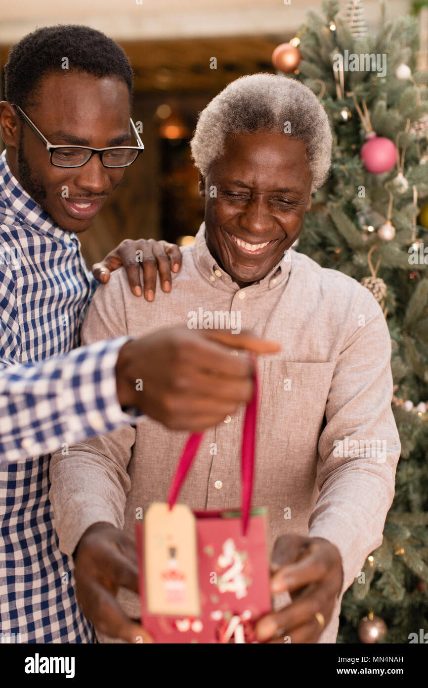 Enkel überraschenden Großvater mit Weihnachtsgeschenk Stockfoto