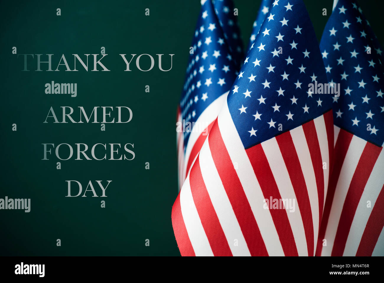 Einige amerikanische Flaggen und den Text Danke und Streitkräfte Tag gegen einen dunkelgrünen Hintergrund Stockfoto